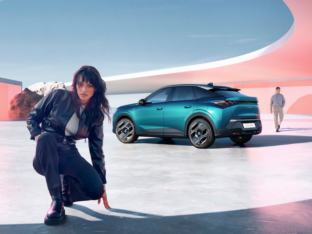 Woman kneeling next to new PEUGEOT 3008 Plug-In hybrid with rear view